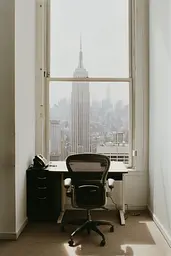 Midjourney generated image using SREF code Urban Solitude: A desk and chair in an empty room with a view of the Empire State Building.