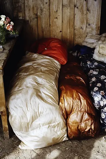 Midjourney generated image using SREF code Rustlight: A pile of pillows sitting on top of a wooden table.