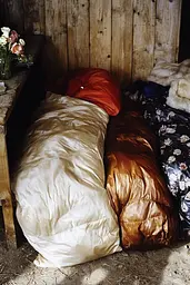 Midjourney generated image using SREF code Rustlight: A pile of pillows sitting on top of a wooden table.