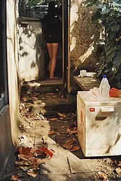 Midjourney generated image using SREF code Rustlight: A woman standing in the doorway of a building next to a refrigerator.