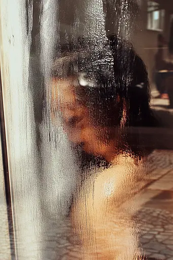 Midjourney generated image using SREF code Rustlight: A reflection of a woman in a glass door.