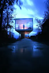 Midjourney generated image using SREF code Haloed Spectres: A person standing in front of a building with a large screen on it.