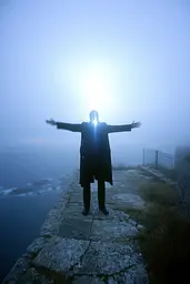 Midjourney generated image using SREF code Haloed Spectres: A man standing on top of a cliff with his arms outstretched.