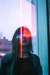 Midjourney generated image using SREF code Cyan Flux: A woman standing in front of a window with a neon light on her face.