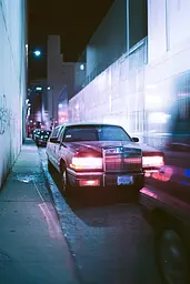 Midjourney generated image using SREF code Cyan Flux: A car parked on the side of a street at night.