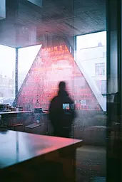 Midjourney generated image using SREF code Cyan Flux: A person standing in front of a window in a building.