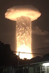 Midjourney generated image using SREF code Hushframe: A large mushroom cloud is seen over a residential area.
