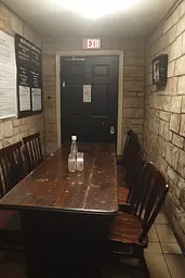 Midjourney generated image using SREF code Hushframe: A long wooden table sitting in a room next to a door.
