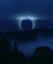 Midjourney generated image using SREF code Gossamer Gaze, Ominous Alienscape, Ethereal Echoes: A blue circle in the sky over a mountain range.