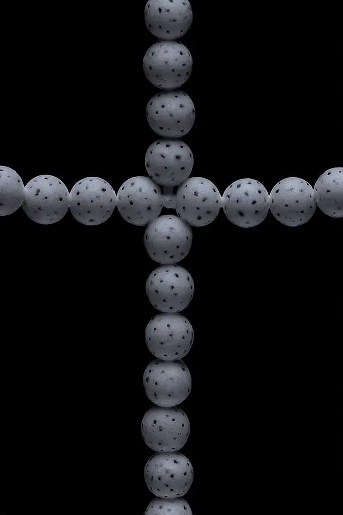 Midjourney generated image using SREF code Squelchloom: A cross made out of golf balls on a black background.