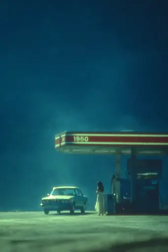 Midjourney generated image using SREF code Blue Velvet: A woman standing in front of a gas station at night.