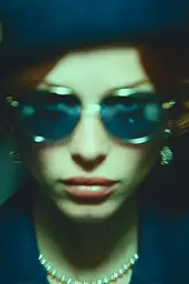 Midjourney generated image using SREF code Blue Velvet: A woman wearing a blue hat and sunglasses.