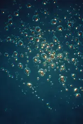 Midjourney generated image using SREF code Blue Velvet: A bunch of bubbles floating in the water.