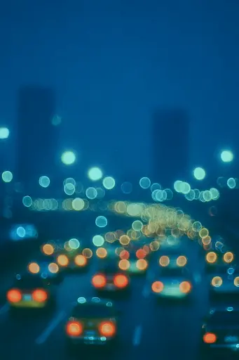 Midjourney generated image using SREF code Blue Velvet: A blurry image of a busy city street at night.