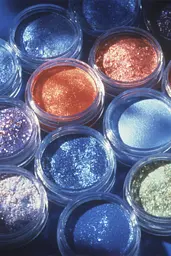 Midjourney generated image using SREF code Phosplasm: A close up of a variety of glitter eyeshadows.