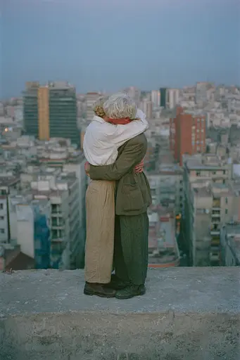 Midjourney generated image using SREF code Hushed Loomlight: A man and woman hugging on top of a building.