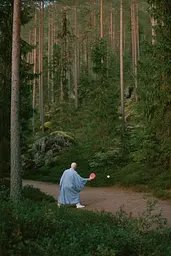 Midjourney generated image using SREF code Hushed Loomlight: A man in a blue robe playing ping pong in the woods.