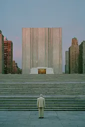 Midjourney generated image using SREF code Hushed Loomlight: A man standing in front of a large building.