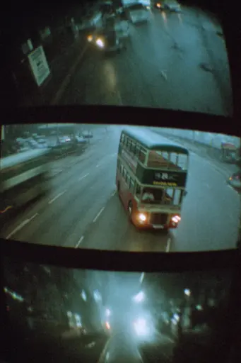 Midjourney generated image using SREF code Glitchmorose: A double decker bus driving down a city street at night.