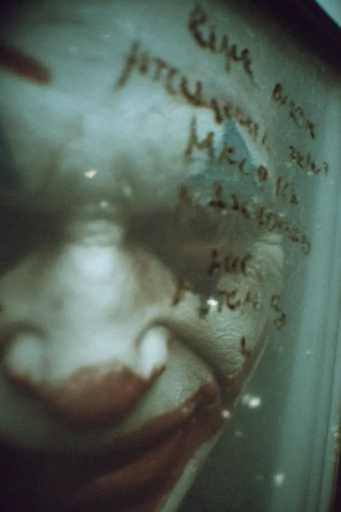 Midjourney generated image using SREF code Glitchmorose: A close up of a baby's face in a glass container.