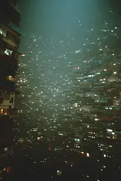 Midjourney generated image using SREF code Glitchmorose: A view of a city at night from the top of a building.