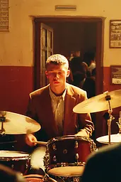 Midjourney generated image using SREF code Coppermuse: A man in a suit playing a drum set.