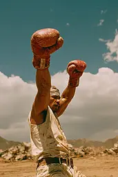 Midjourney generated image using SREF code Coppermuse: A man in a white shirt and red boxing gloves.