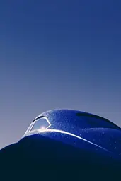 Midjourney generated image using SREF code Bluephantasm: A blue car with a blue sky in the background.