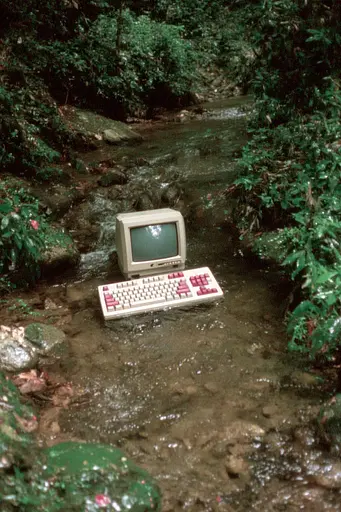 Midjourney generated image using SREF code GlimmerDial: A computer sitting in the middle of a stream.
