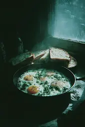 Midjourney generated image using SREF code Twilight Smog: A pan of eggs and bread sitting on a window sill.