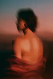 Midjourney generated image using SREF code Blurloom: A blurry image of a woman in a red dress.