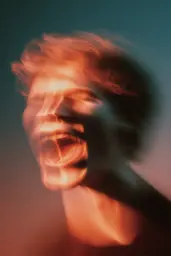 Midjourney generated image using SREF code Blurloom: A blurry image of a man singing into a microphone.