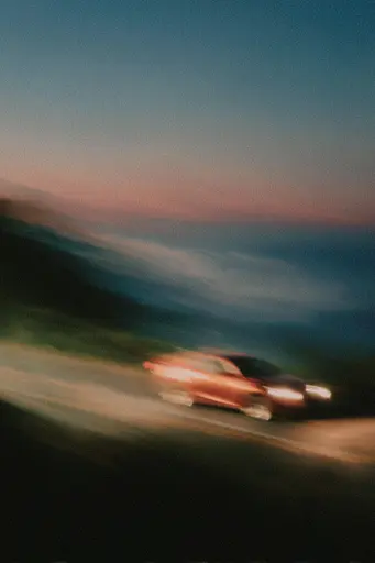 Midjourney generated image using SREF code Blurloom: A blurry image of a car driving down a road.