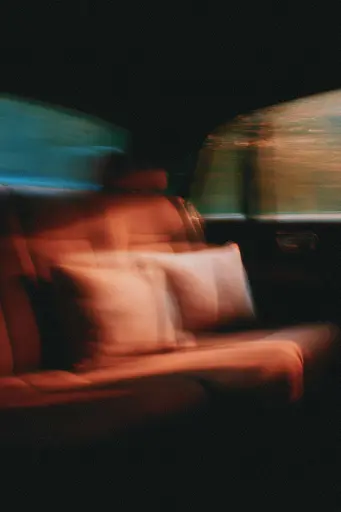Midjourney generated image using SREF code Blurloom: A blurry image of a person sitting in a car.