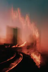 Midjourney generated image using SREF code Blurloom: A large fire is burning in the middle of a street.