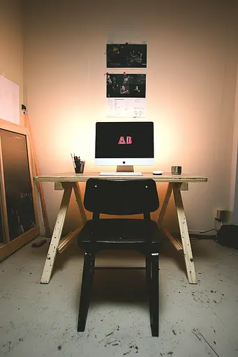 Midjourney generated image using SREF code Rebel Abyss: A desk with a computer and a chair in a room.