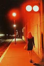 Midjourney generated image using SREF code Amber Memoirs: A woman walking down a sidewalk at night. 