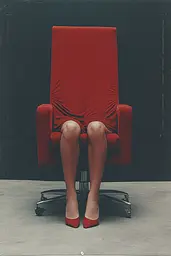 Midjourney generated image using SREF code Eclipse Visions: A woman sitting in a red chair with her legs crossed.