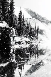 Midjourney generated image using SREF code Monochrome Shards: A black and white photo of a mountain reflected in a lake.