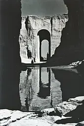 Midjourney generated image using SREF code Gritty Dissonance: A black and white photo of a man standing in front of a cave.